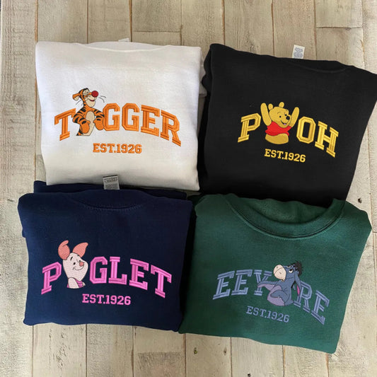 Folded Winnie The Pooh Characters Sweatshirts Displayed On Wooden Surface