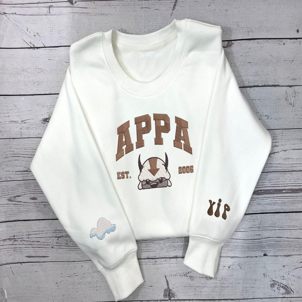 White sweatshirt with embroidered Appa and sleeve icons.