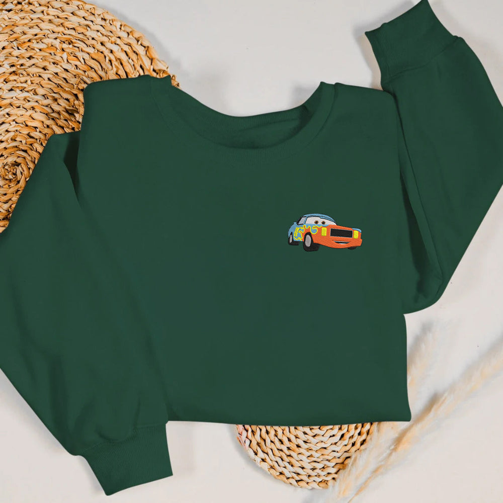 Forest green Darrell Cartrip embroidered sweatshirt on straw mat