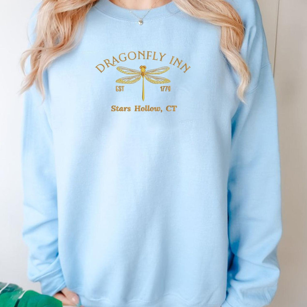 Baby blue Dragonfly Inn crewneck, casual standing model pose