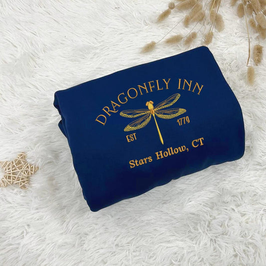 Navy Dragonfly Inn Est.1779 sweatshirt on fluffy white fur