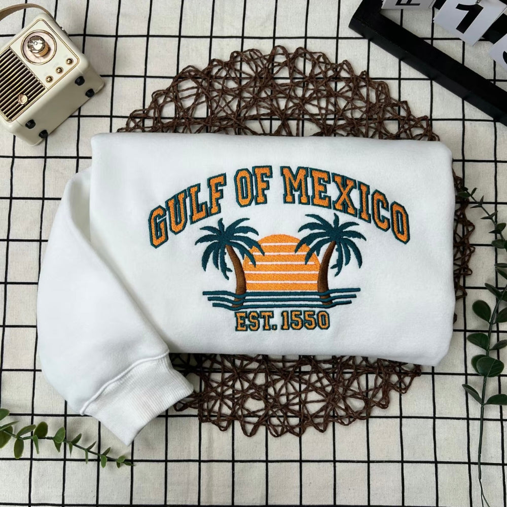 Folded white Gulf of Mexico crewneck with palm tree embroidery