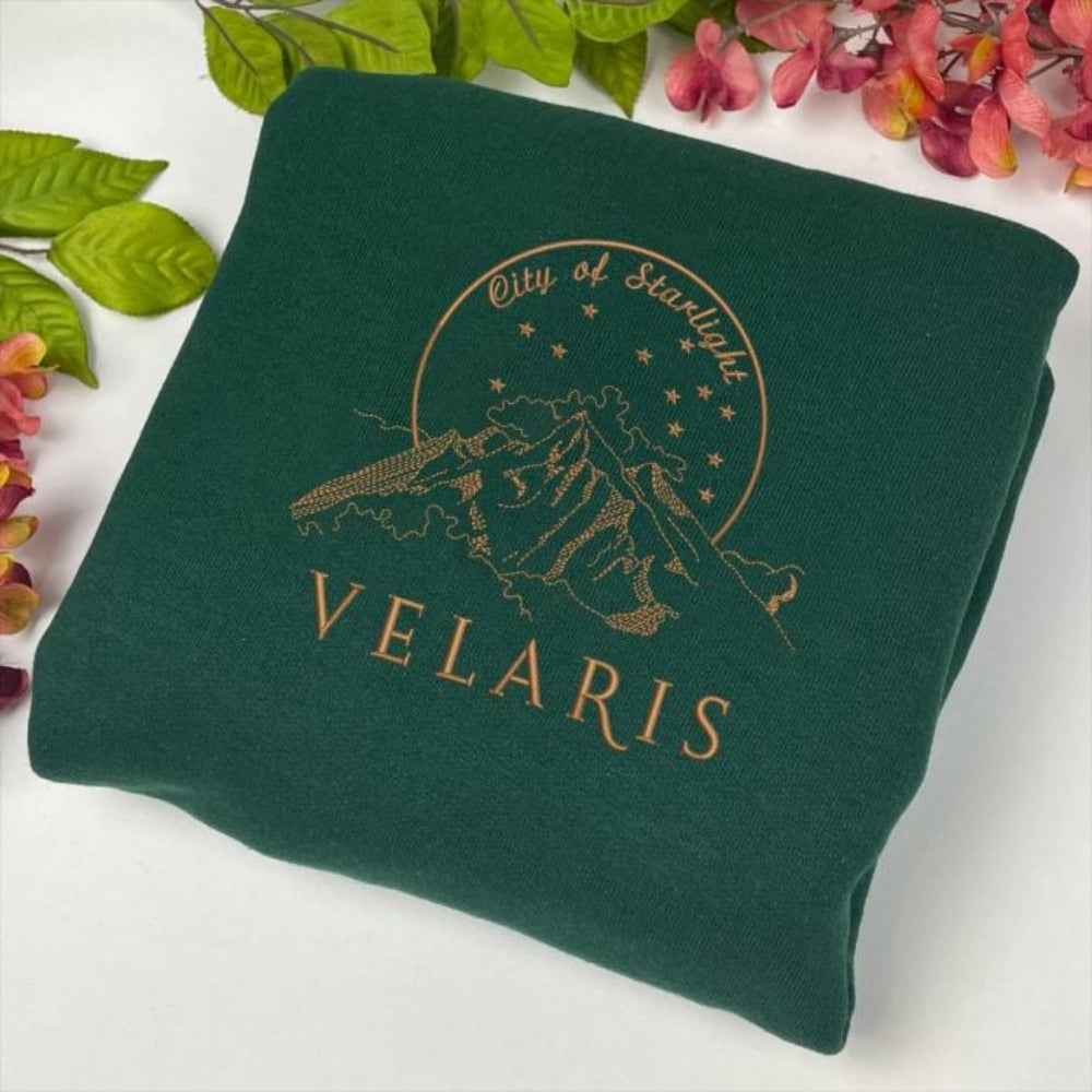 Emerald Velaris starry night sweatshirt surrounded by pink flowers