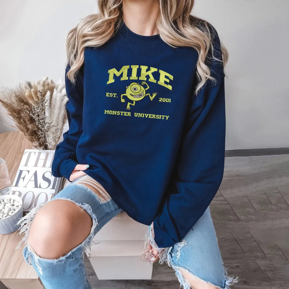 Navy Sweatshirt With Mike Wazowski Monster University Embroidery On Model.