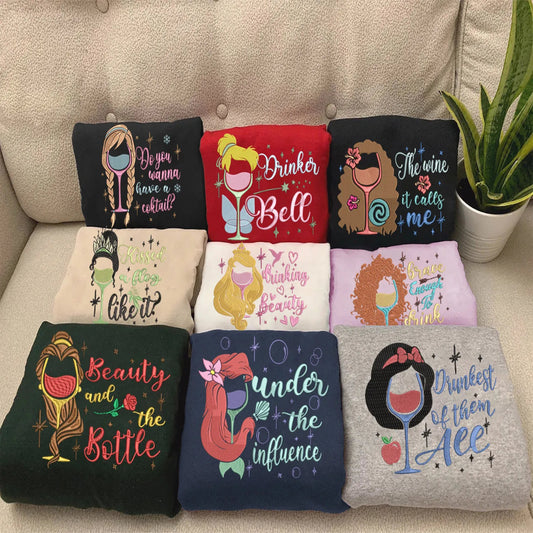 Collection Of Disney Princess Wine Pun Embroidered Sweatshirts Folded Together.
