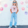 Girl In Pink Minnie Witch Disneyland T-Shirt Against Smiley Wall