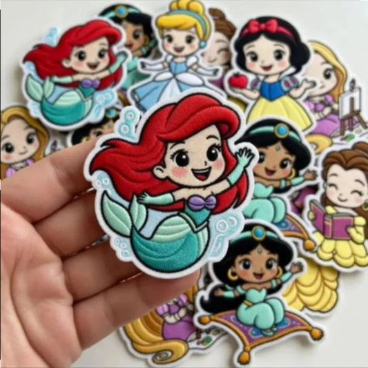 Hand Holding Chibi Ariel Above Collection Of Disney Princess Patches

