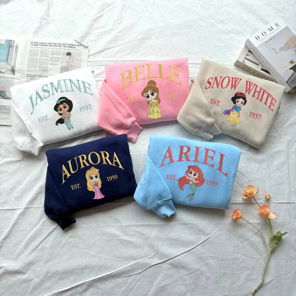 Assorted Pink, Blue, Beige, Navy Princess Chibi Sweatshirts On Bed