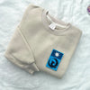 Sweatshirt Folded Displaying Minnesota Loon Bird Flag Patch On Chest
