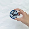 Hand Holding Mockingjay Embroidered Patch With Sharp Stitching