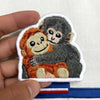 Hand Holding Cute Baby Monkeys Hugging Embroidered Patch.
