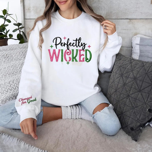 White "Perfectly Wicked" Embroidered Sweatshirt In Cozy Setting.