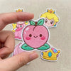 Close-Up Of Embroidered Peach Face Patch With Blush, Crown Details