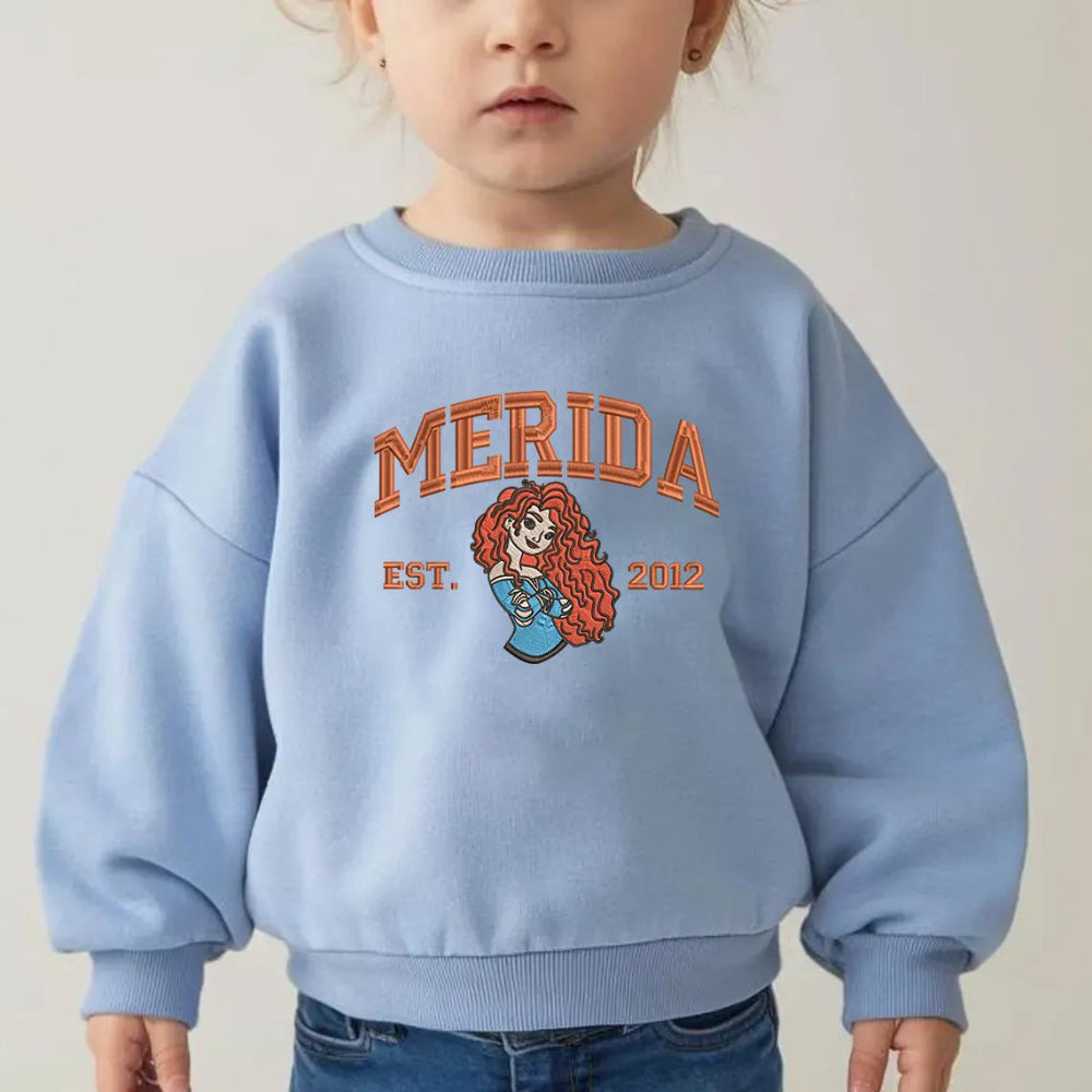 Toddler Wearing Light Blue Merida Embroidered Sweatshirt With Orange Text