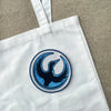 White Sweatshirt Close Up With Circular Rebel Loon Embroidered Patch