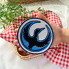 Hand Holding Round Minnesota Rebel Loon Patch With Blue Border