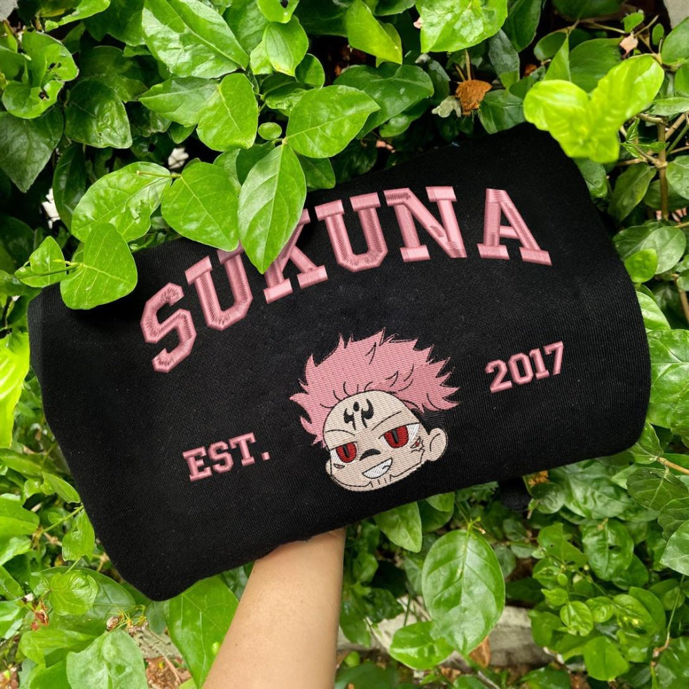 Black Sukuna Pink Face Embroidered Sweatshirt Held Outdoors