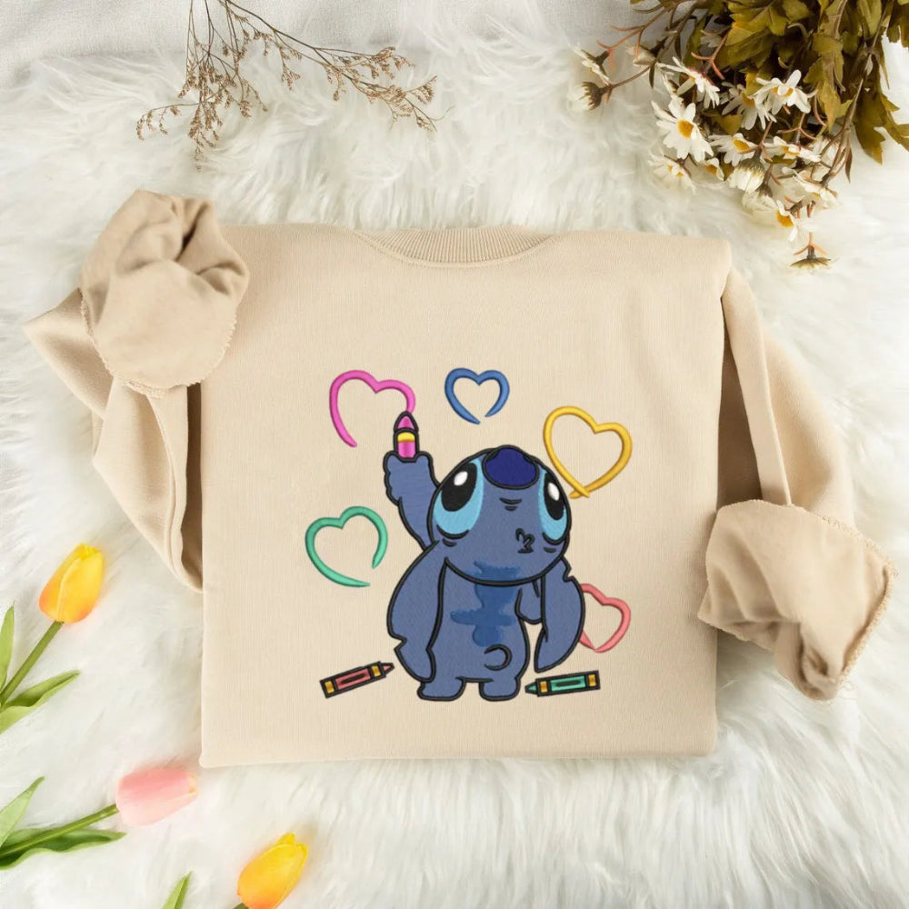 Sand Colored Sweatshirt Featuring Stitch Holding A Pink Crayon Graphic