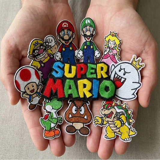 Hands Holding Collection Of Colorful Super Mario Patches 
