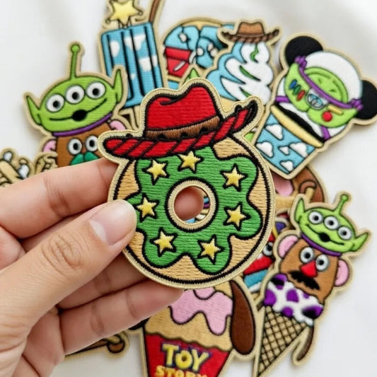 Hand Holding Donut Patch With Red Cowboy Hat, Yellow Stars
