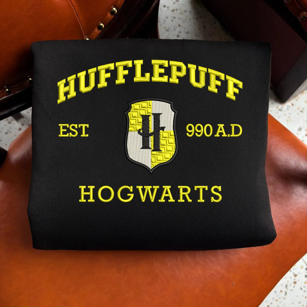 Folded Black Hufflepuff Sweatshirt Featuring Yellow Embroidered Crest And Text