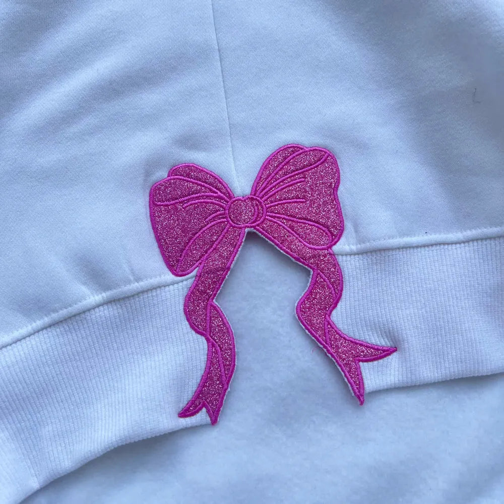 Sparkly Pink Embroidered Bow on White Fabric