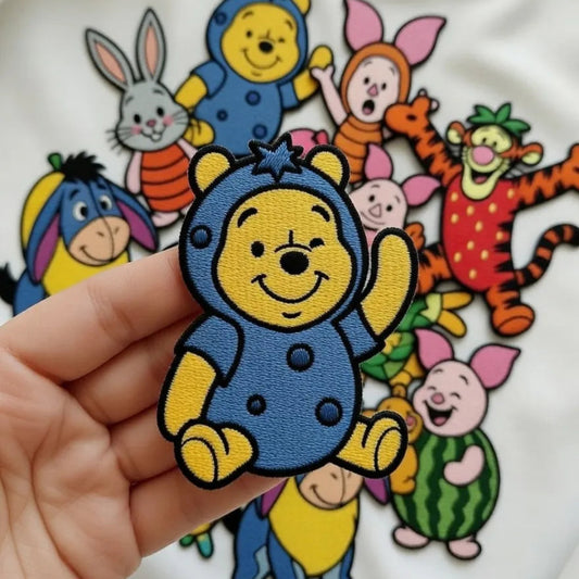 Hand Holding Chibi Winnie The Pooh In Blueberry Costume Waving
