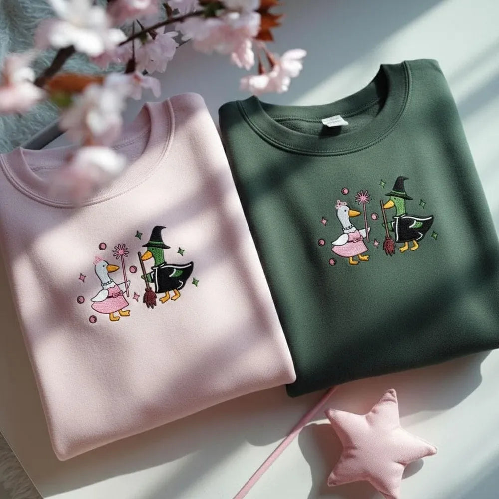 Pink and Green Embroidered Goose Sweatshirts Displayed with Soft Lighting